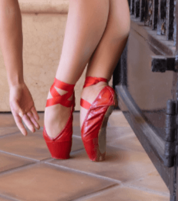 Dancer wearing red lacquer pointe shoes
